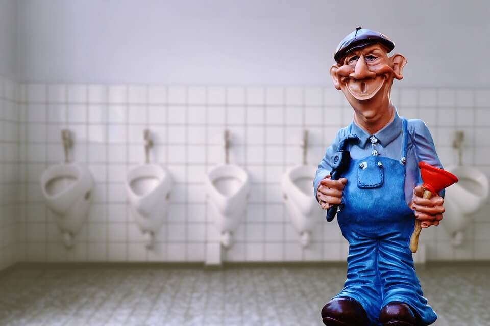 Plumber Figure with Plunge on a Public Toilet after Toilet Unclogging