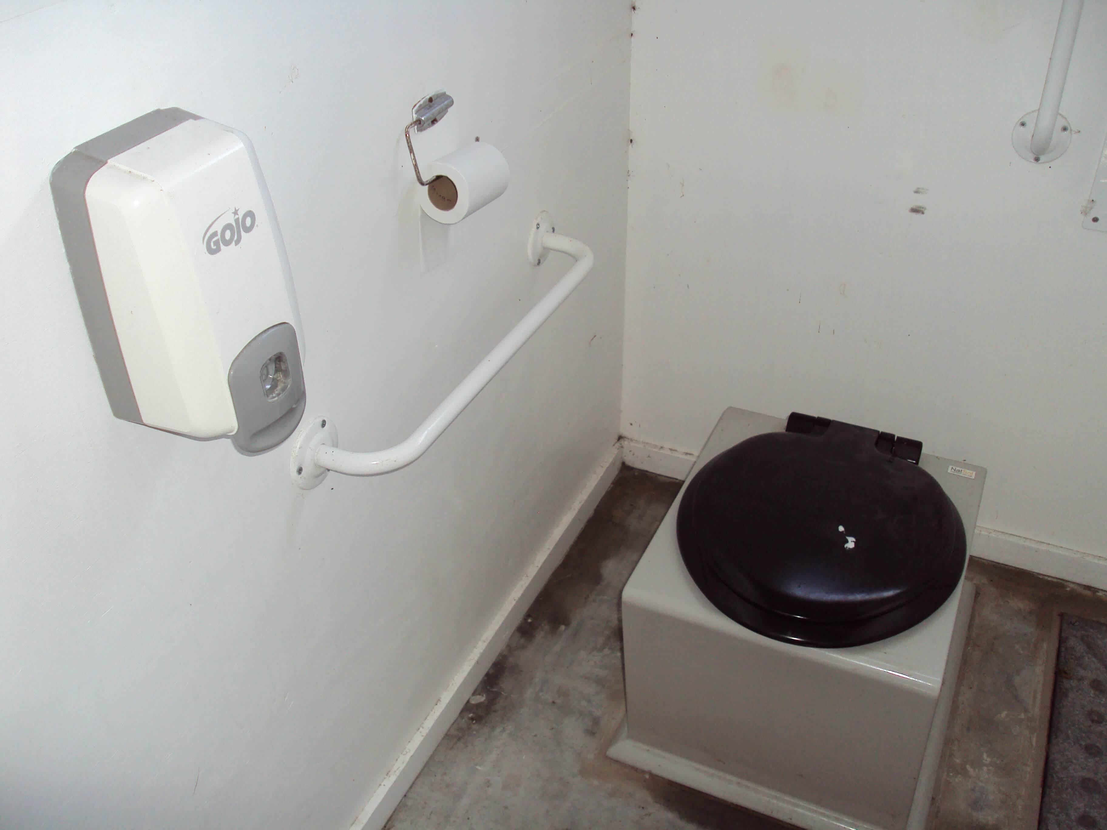 Composting toilet on Hilbre Island, Wirral, England with tissue dispenser and hand sanitizer 