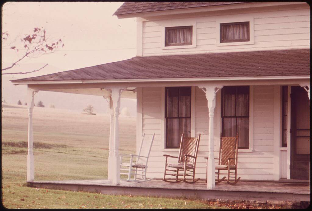 Plumbing problems: Old farmhouse with rocking chairs on the porch